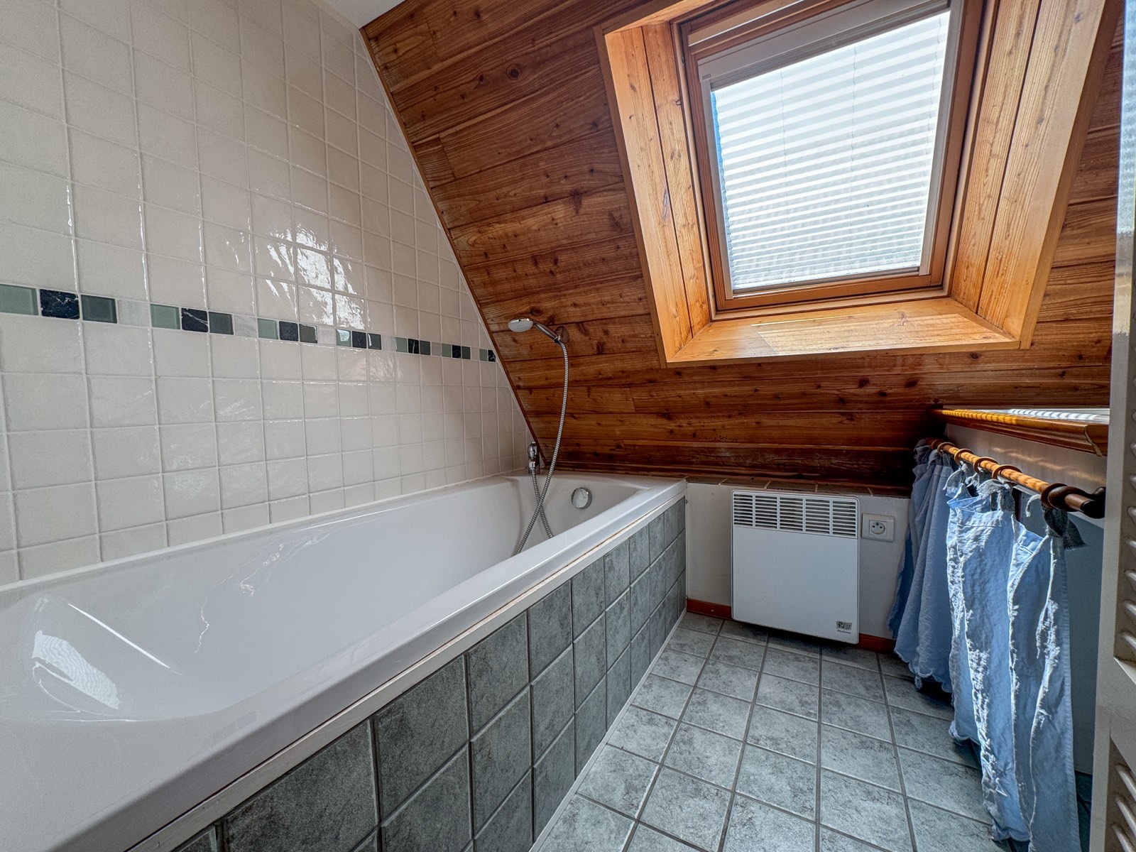 Badkamer met ligbad onder het dakraam in Moulin Noix