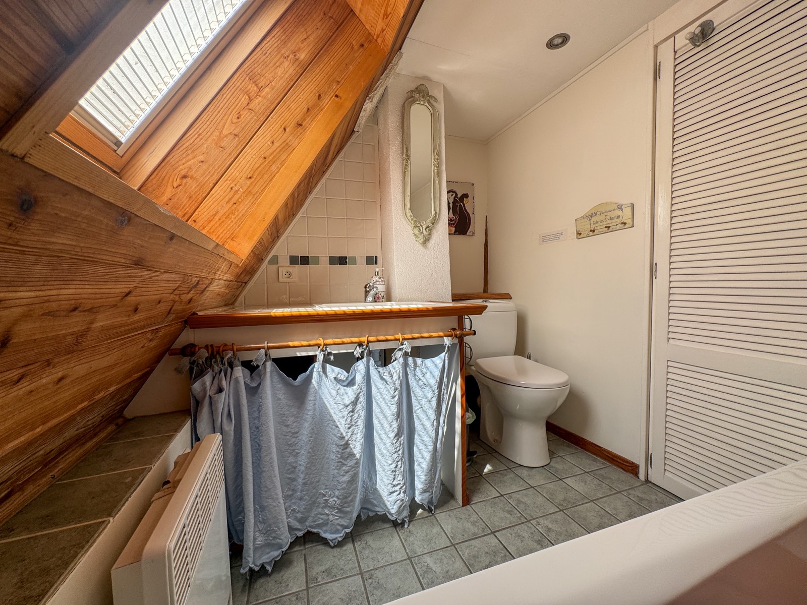 Badkamer op de zolderverdieping met wastafel en toilet in Moulin Noix