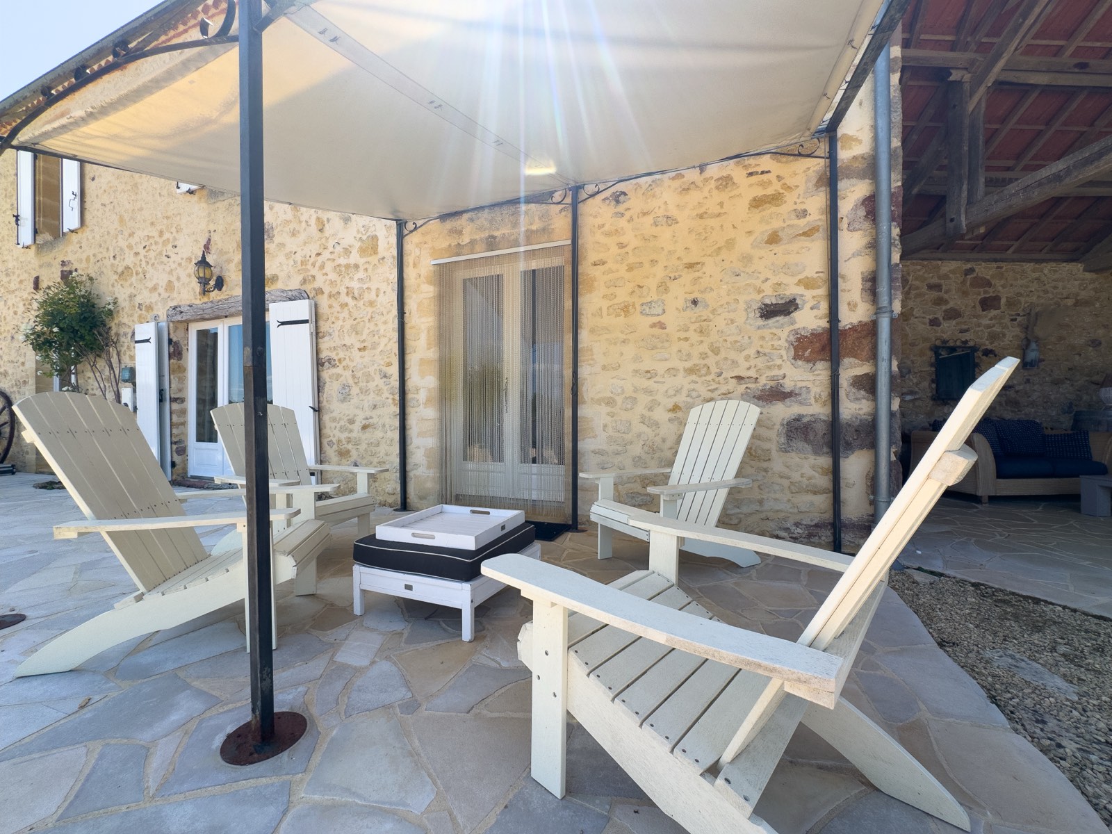 Terras met loungestoelen onder de partytent bij Moulin Noix