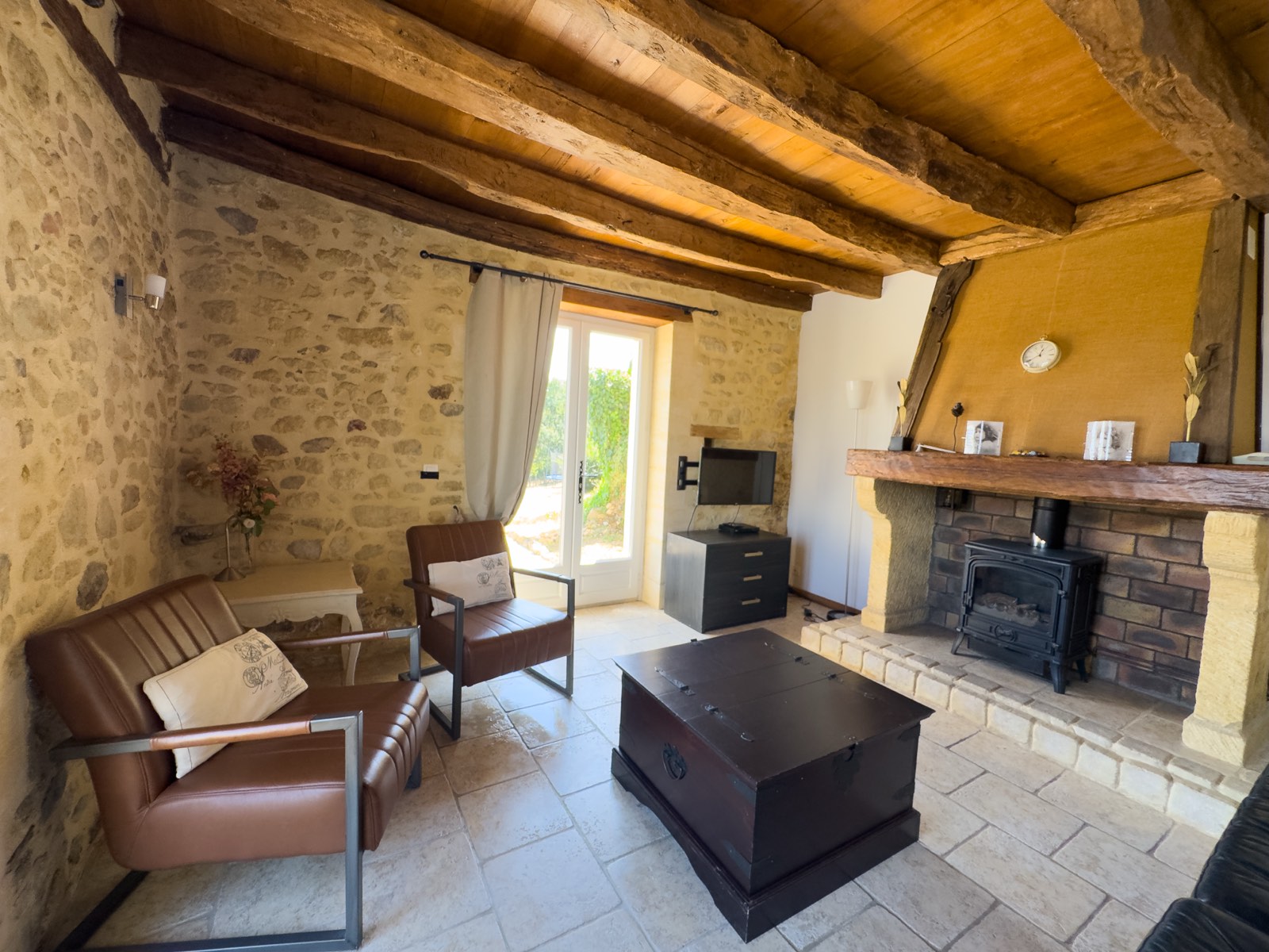 Woonkamer met houtkachel en zithoek in vakantiehuis Moulin Noix