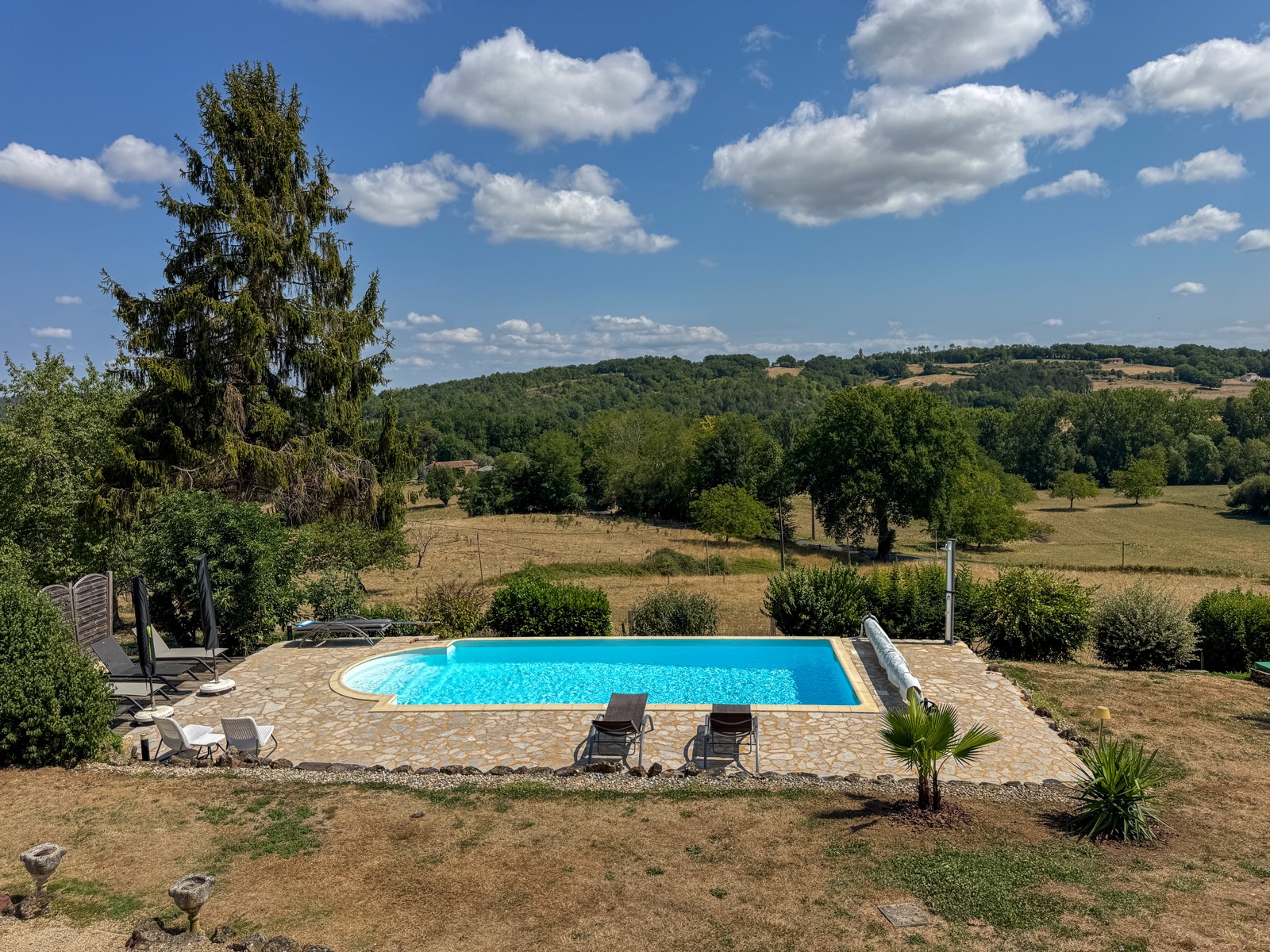 Panorama van het privezwembad met uitzicht over de heuvels van de Dordogne